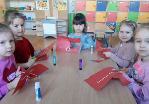 Dziewczynki wykonują walentynkowe serduszko z papieru.